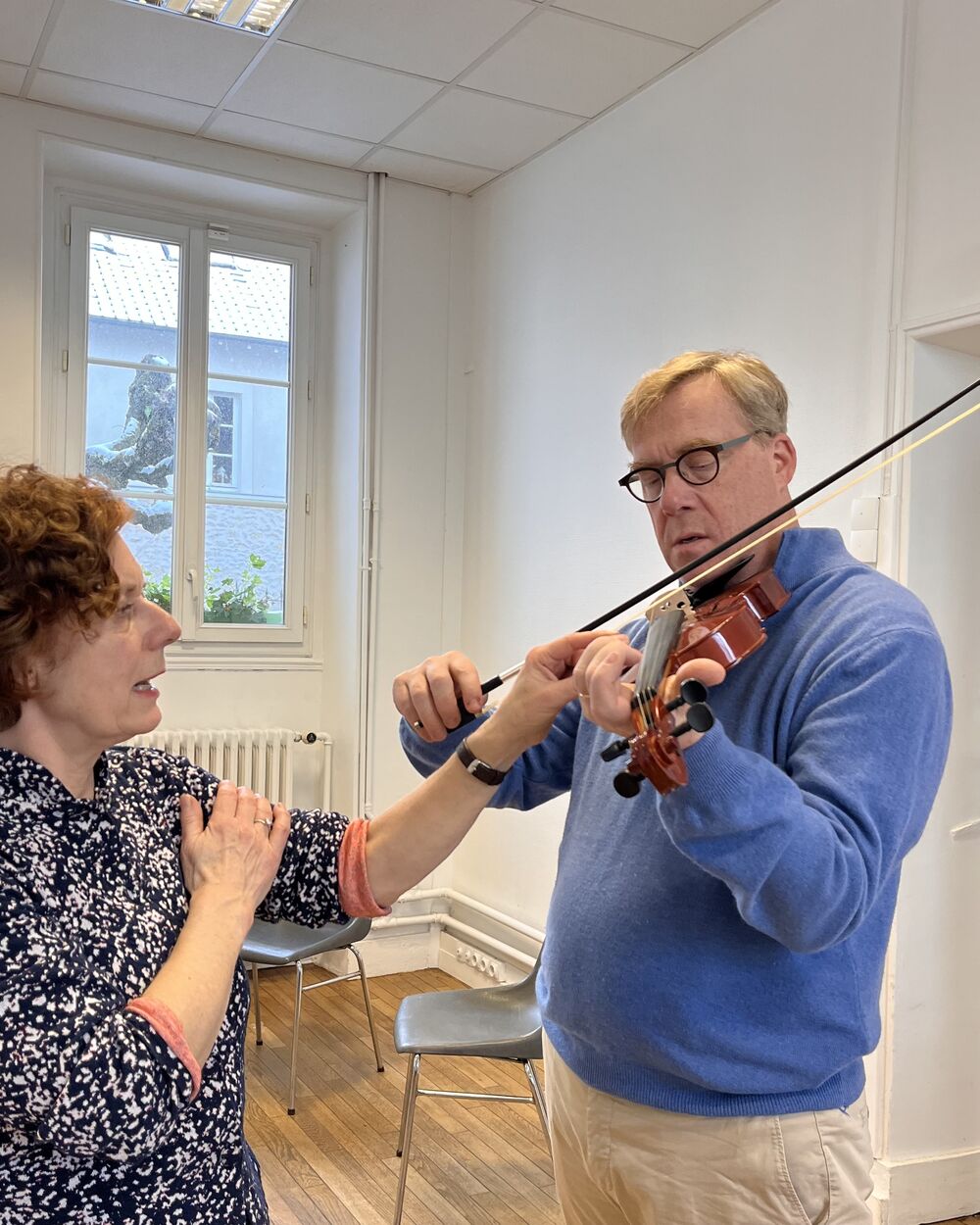 Petra montre à un participant comment tenir le violon